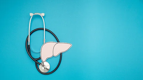 A stethoscope and liver shape made of paper are over a blue background A stethoscope and liver shape made of paper are over a blue background
