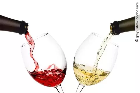 Rot- und Weißwein werden in 2 Weingläser eingeschenkt