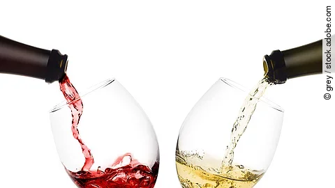 Rot- und Weißwein werden in 2 Weingläser eingeschenkt