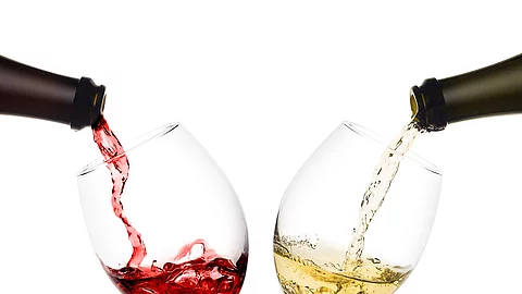 Rot- und Weißwein werden in 2 Weingläser eingeschenkt Rot- und Weißwein werden in 2 Weingläser eingeschenkt