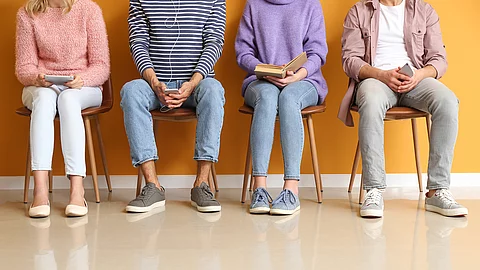 Young people waiting in line near color wall