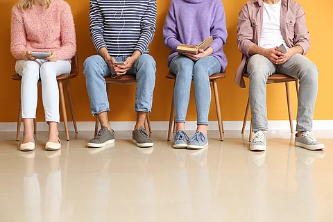 Young people waiting in line near color wall