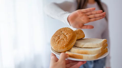 Young woman on gluten free diet is saying no thanks to toast. A