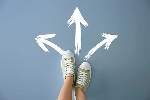 Woman standing on color background with arrows pointing in diffe