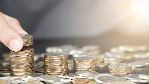 Man hand putting coins stacking for growth business and saving i Man hand putting coins stacking for growth business and saving i