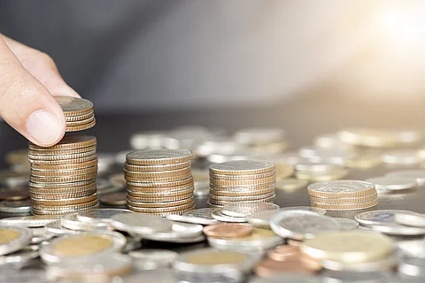 Man hand putting coins stacking for growth business and saving i