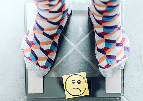 Sockige Füße auf Waage