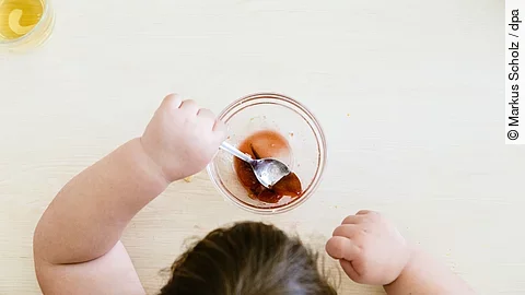 Ein übergewichtiges Kind sitzt am Tisch und isst.