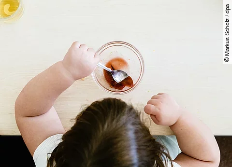 Ein übergewichtiges Kind sitzt am Tisch und isst. Ein übergewichtiges Kind sitzt am Tisch und isst.