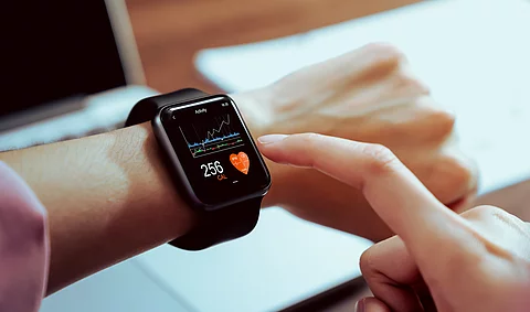 Close up of hand touching smartwatch with health app on the scre