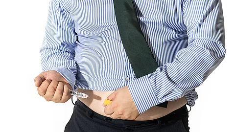 A man injecting himself with obesity medication
