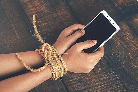Hands tied by strong rope with mobile Hands tied by strong rope with mobile