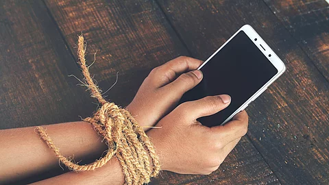 Hands tied by strong rope with mobile Hands tied by strong rope with mobile