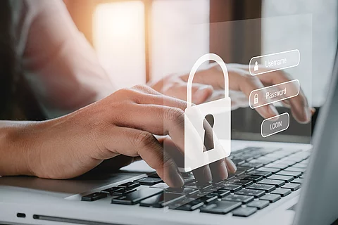 Woman hand typing on keyboard with login and password on screen 