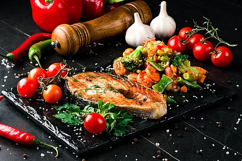Steam salmon and vegetables, Paleo, keto, fodmap diet on old rustic wooden table