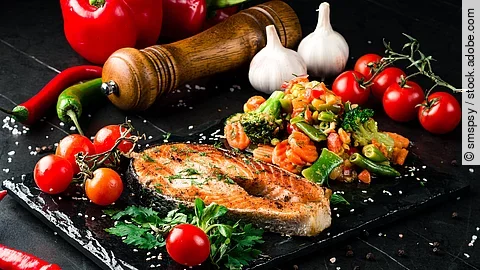 Steam salmon and vegetables, Paleo, keto, fodmap diet on old rustic wooden table