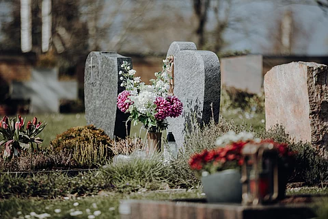 grave stone with flowers at graveyard