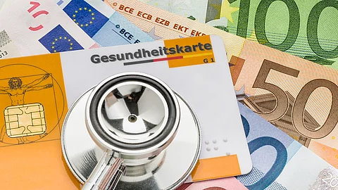 Stethoskop mit Gesundheitskarte auf Geldscheinen Gesundheitskarte, Stethoskop und Euro-Scheine