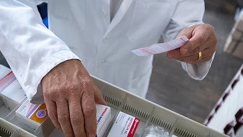 Apotheker checkt, ob rezeptpflichtiges Medikament vorrätig ist.