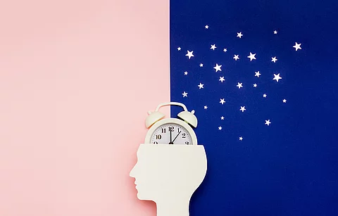Silhouette of human and alarm clock on pink and blue backgrounds Silhouette of human and alarm clock on pink and blue backgrounds