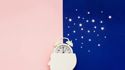 Silhouette of human and alarm clock on pink and blue backgrounds Silhouette of human and alarm clock on pink and blue backgrounds