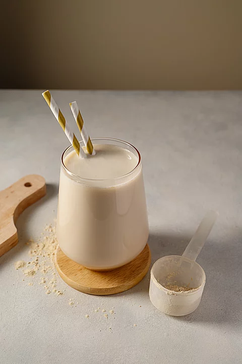 Healthy chocolate protein shake drink with straw, and protein powder